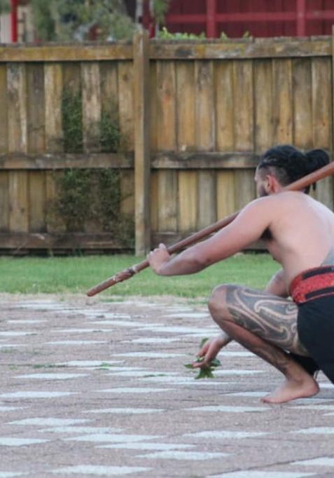 Our kaiwero runs out of the wharenui (meeting house) holding his taiaha (traditional wooden weapon).